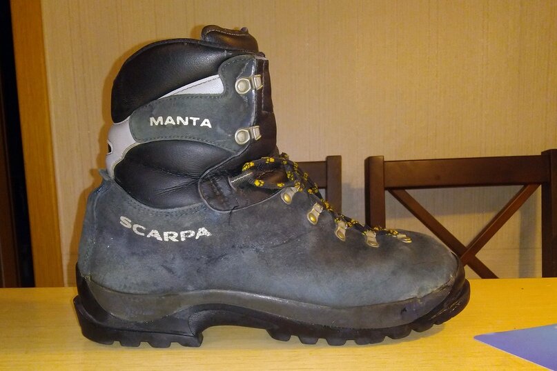 Горный  ботинок бренда SCARPA, сделан из нубука и кожи, носок и пятка  усиленные, очень жесткая подошва - не прогибается, когда идешь,  ощущение, что к ноге доска привязана. На носке и пятке виднеются выступы  — ранты, они используются для крепления кошек и я использую для  закрепления лыжных креплений. 