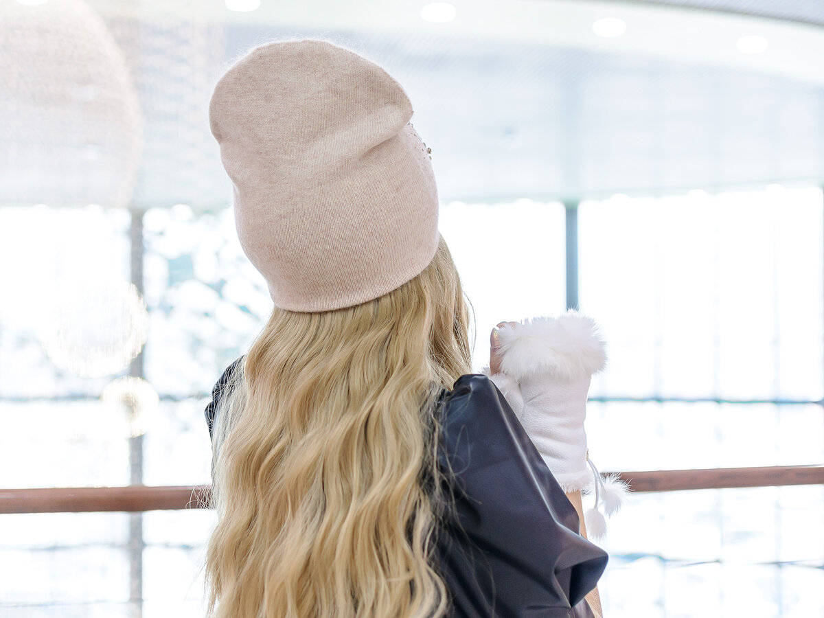 Блондинка в шарфе и шапочке со спины