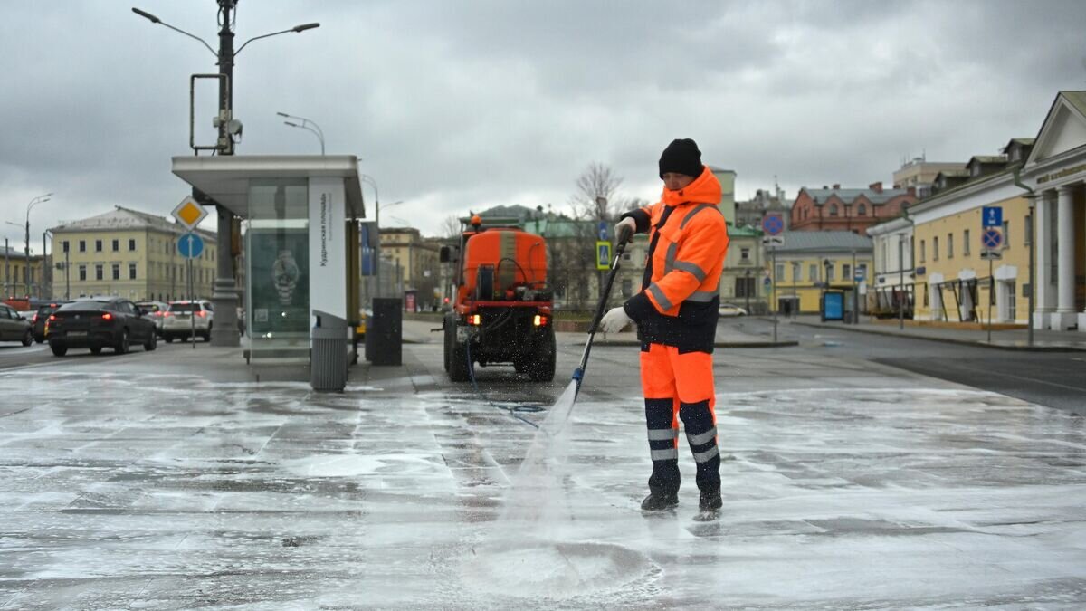    Сотрудник коммунальной службы моет тротуар на Кудринской площади в Москве© РИА Новости / Евгений Одиноков