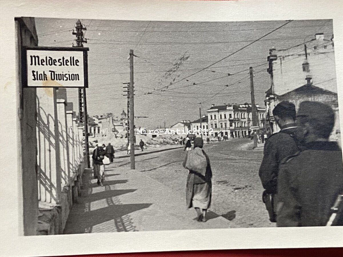 Улица Сергиевская ( при немцах переименованная в Гитлерштрассе). Вид в строну разрушенного квартала многоэтажных домов. Справа разрушенный и уже разобранный красивый дом Шпинка. Дом Гессе уцелел. В конце улицы дом Лоховых. Но здесь я бы обратил внимание на табличку слева. Meldestelle Flak Division - явочный пункт зенитной дивизии. В 1942 году группу армий "Север" прикрывала 2 дивизия ПВО. В самом Пскове зенитных батарей было не так уж много, но все отпускники неизбежно проходили через Pleskau. Отсюда уже можно было уехать в отпуск в пассажирском вагоне. По всему городу находилось множество сборных пунктов других частей. 