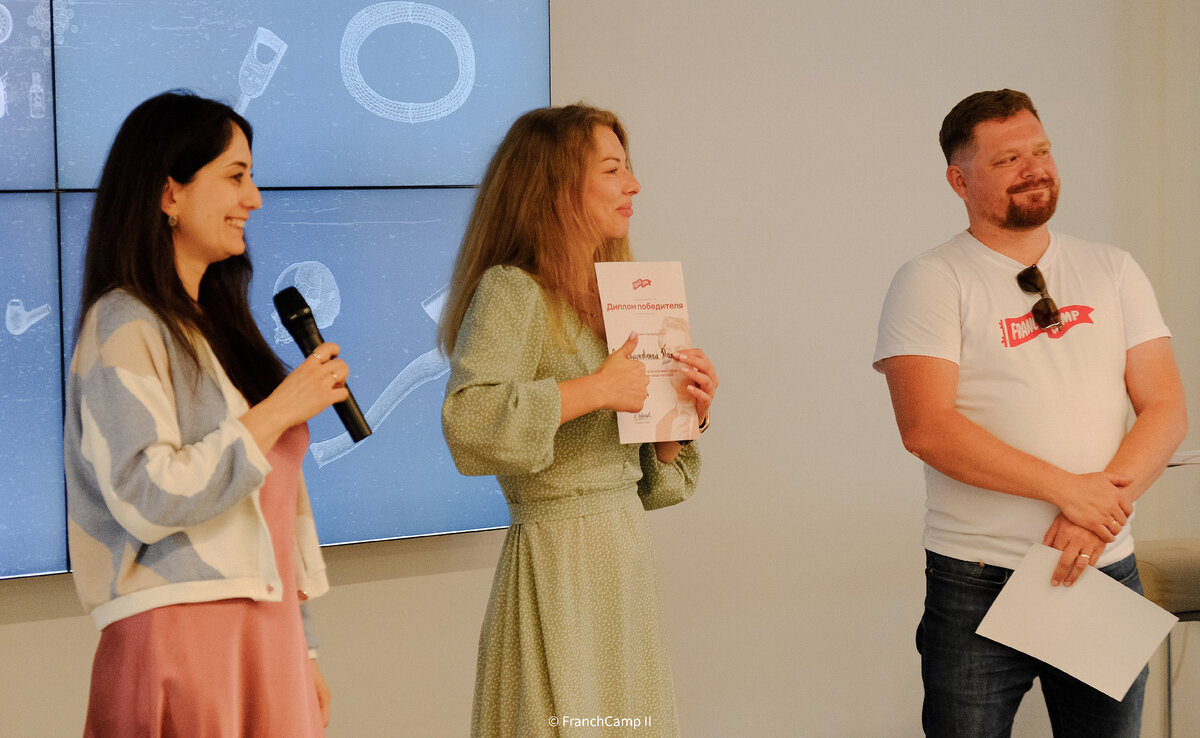 Елена Мингова (слева) и Константин Урванцев (справа) награждают одного из победителей конкурса на получение инвестиций Татьяну Закаблуковскую (в центре)