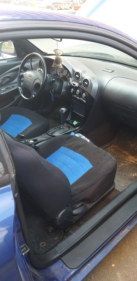 Широкий порог, панель вокруг водителя создают боевое настроение. Жаль, что на руль не хватило у корейцев запала. Источник фото - https://auto.ru/cars/used/sale/hyundai/coupe/1101205352-5e930ab9/