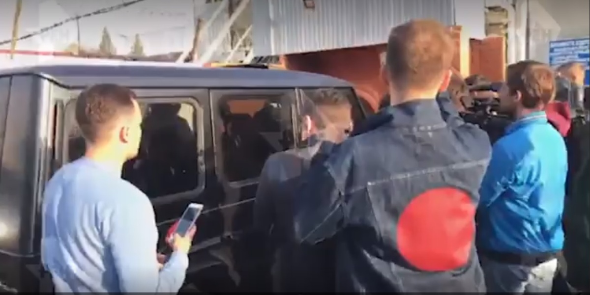 отец Кокорина пытается проехать сквозь толпу  репортеров