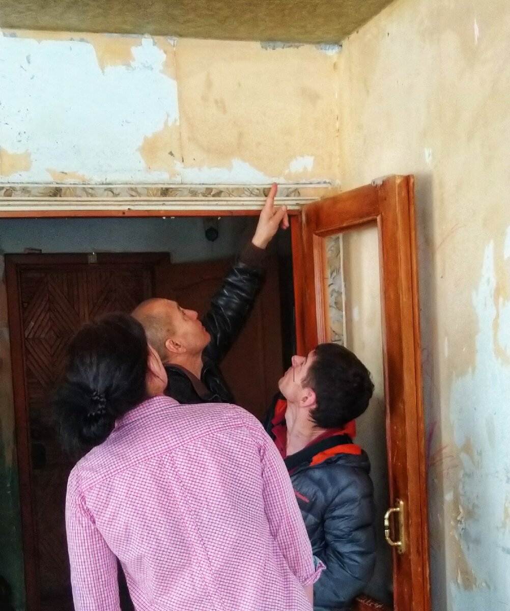 Ильмира и ребята из объединения "Совет отцов Миасса" смотрят проблемные места в квартире.