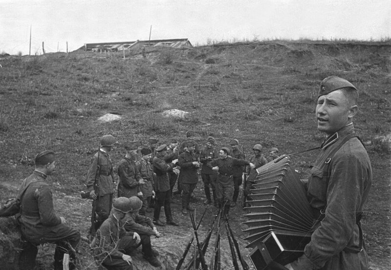 Советский солдат-гармонист и отдыхающие бойцы РККА. Октябрь 1942 года. Автор: Наталья Боде. Источник фото сайт waralbum.ru