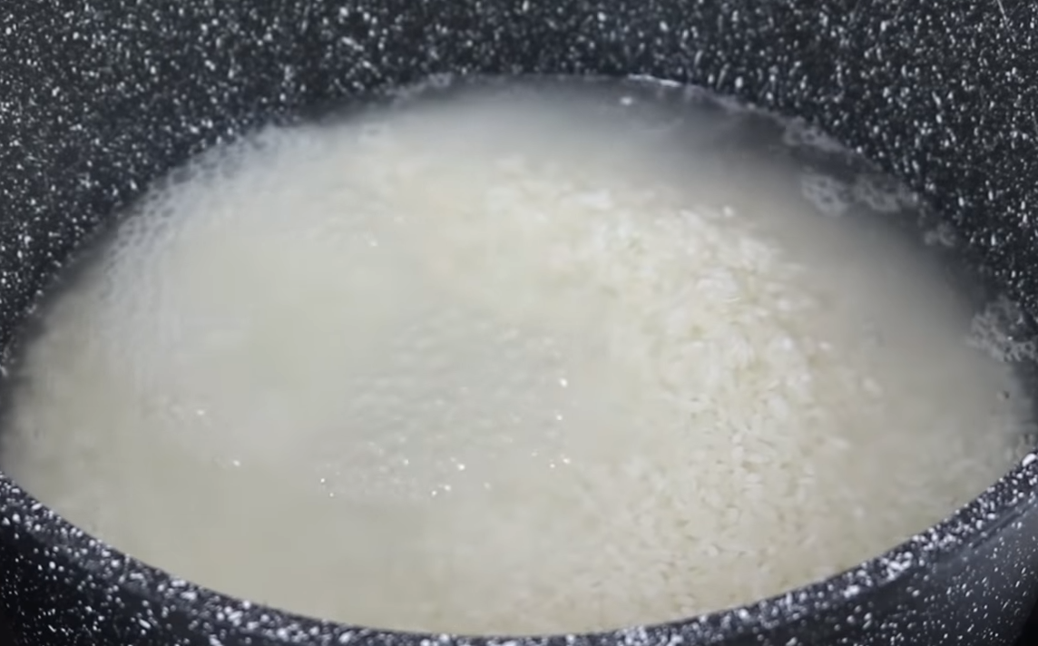 Залить рис водой и поставить на огонь. Закрыть крышкой и довести до кипения.