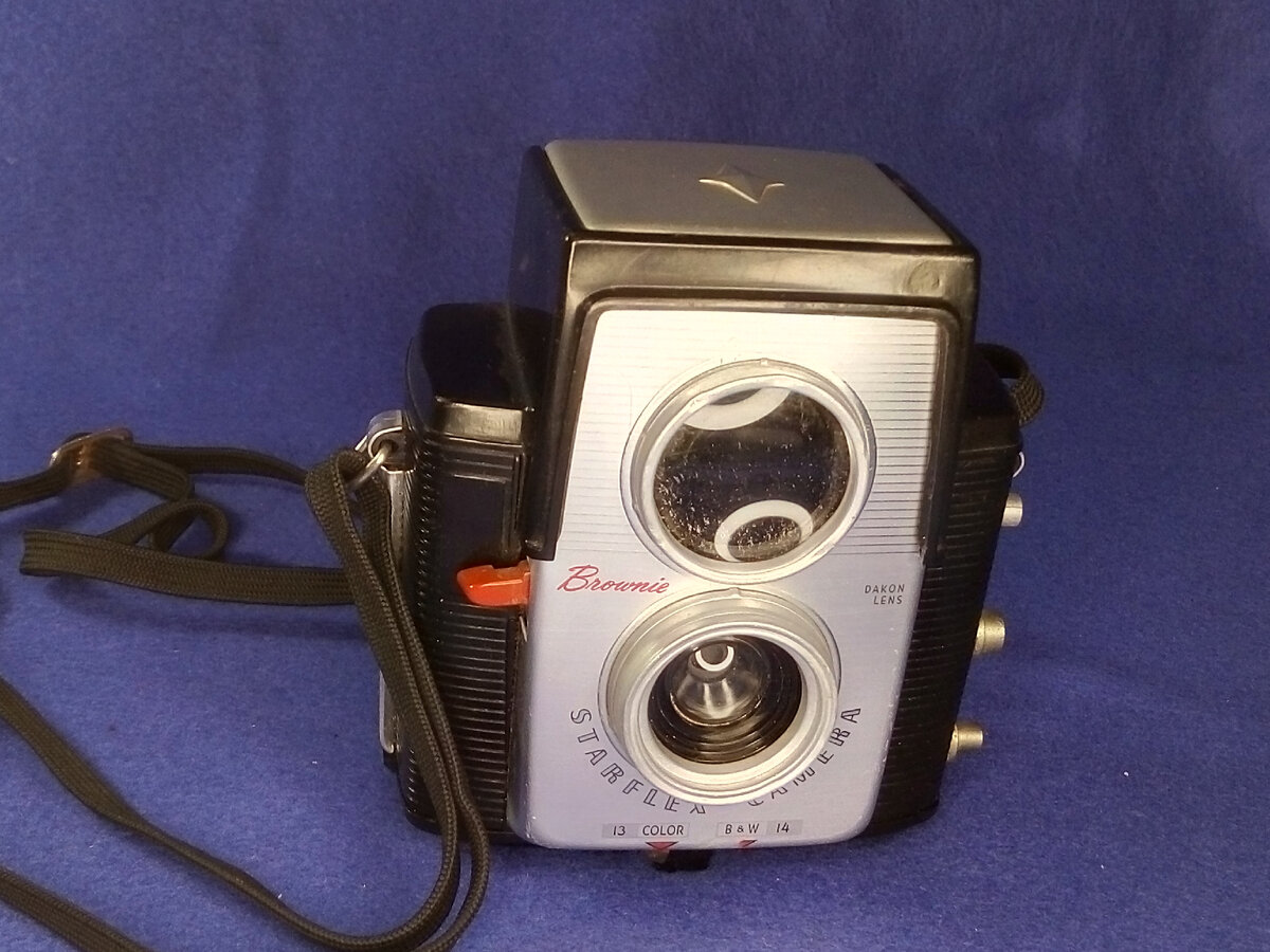 Камера с ремешком. Линза видоискателя (сверху) даже больше самого объектива.