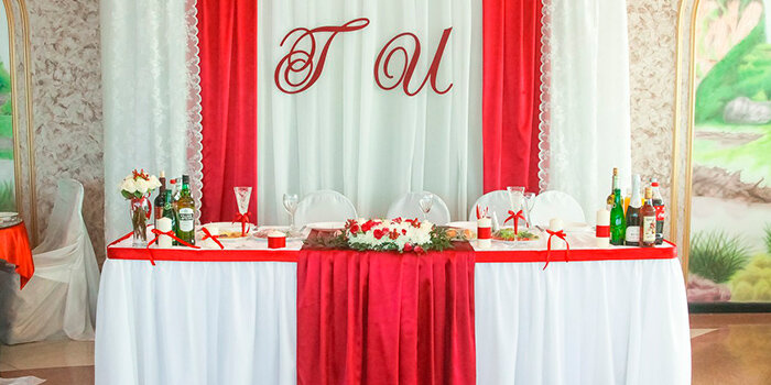 Оформители этой свадьбы в красном цвете выбрали интересное сочетание белого и красного текстиля плюс расположили полосы на столе и заднем фоне вертикально  