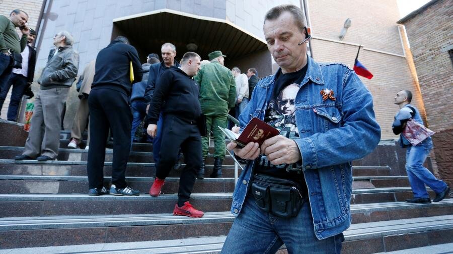 Мужчина держит паспорт у здания миграционной службы в Донецке                                   Фото: REUTERS/ALEXANDER ERMOCHENKO