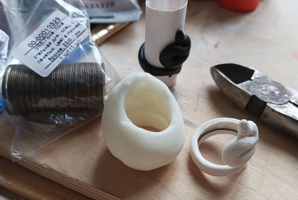 Черная змейка - исходник с которого снята форма. Белая формованная с вставленной проволокой.