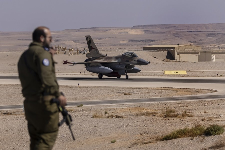 Израильский офицер наблюдает за истребителем F-16 - Фото: Tsafrir Abayov/AP/TASS