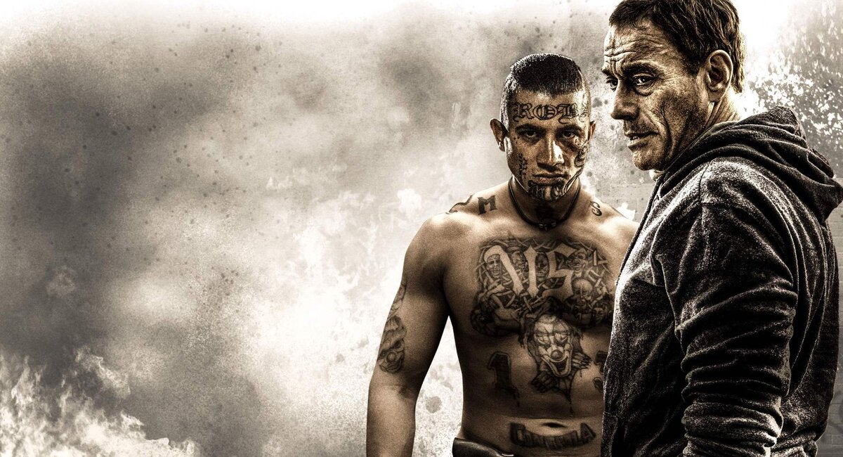 Жан-Клод Ван Дамм никогда не плыл по течению мейнстрима в окружении «успешных людей», торгующих своей харизматичной бицухой в чужих проектах. Свою звездную карьеру он натурально пробивал вертушками, неделями ночуя на ковриках у продюсерских офисов, вкладывая в свои фильмы личное понимание драмы и эстетики схватки. Был сценаристом и постановщиком хореографии боев всех своих классических хитов, в некоторых еще и режиссером этих сцен. Не говоря уже о том, что в каждой зарубе ставил в кадр надежных, убедительных людей. Не «успешных» – зритель все равно не знал кто всё это бычье из подвальных спортзалов – а именно понимающих суть мордобоя. В жанре кино-единоборств Ван Дамма и Брюса Ли просто не с кем больше сравнить (Сигал ближе всех, но он немного про другое) – они задали направления, которыми остальные следуют в меру своих способностей.