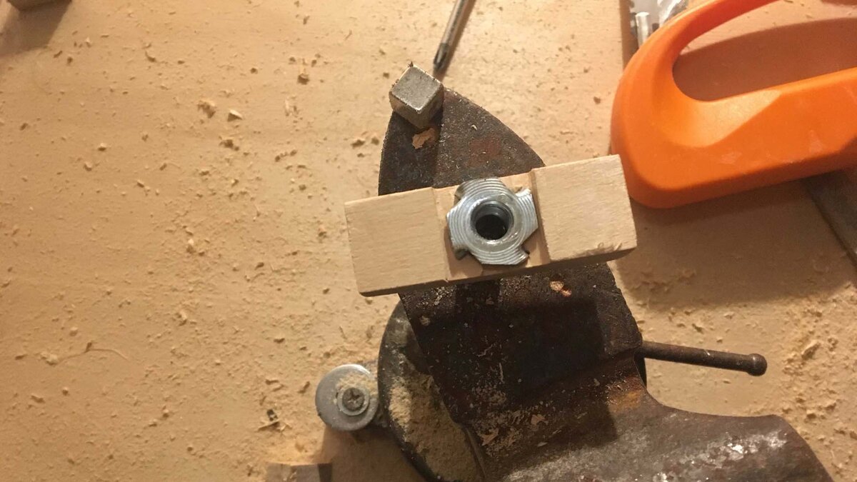 Врезная гайка, запрессованная тисками в плашку
