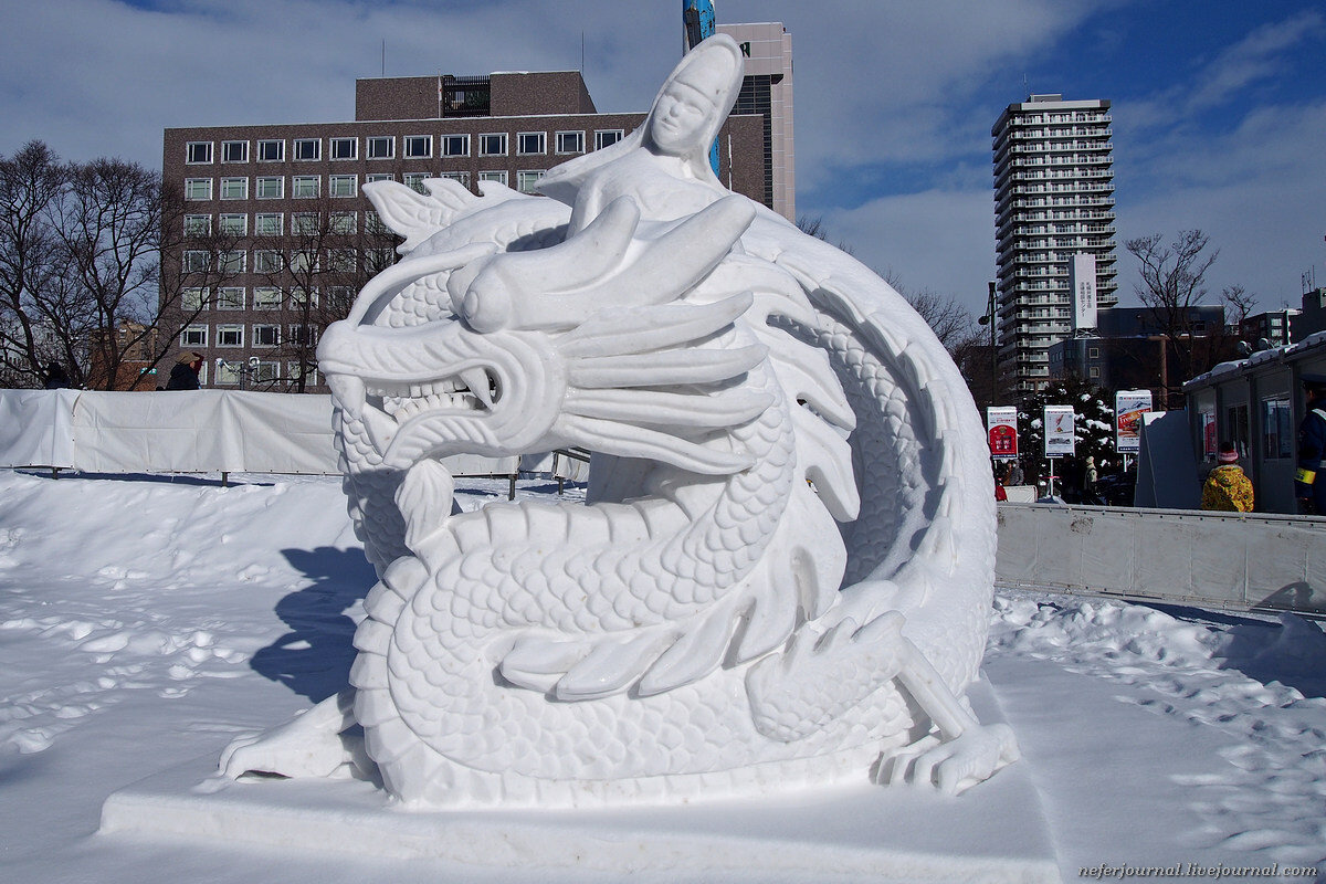 Голова дракона на снегу. Снежные скульптуры. Снежная фигура дракон. Снежная скульптура дракона. Красивые фигуры из снега.