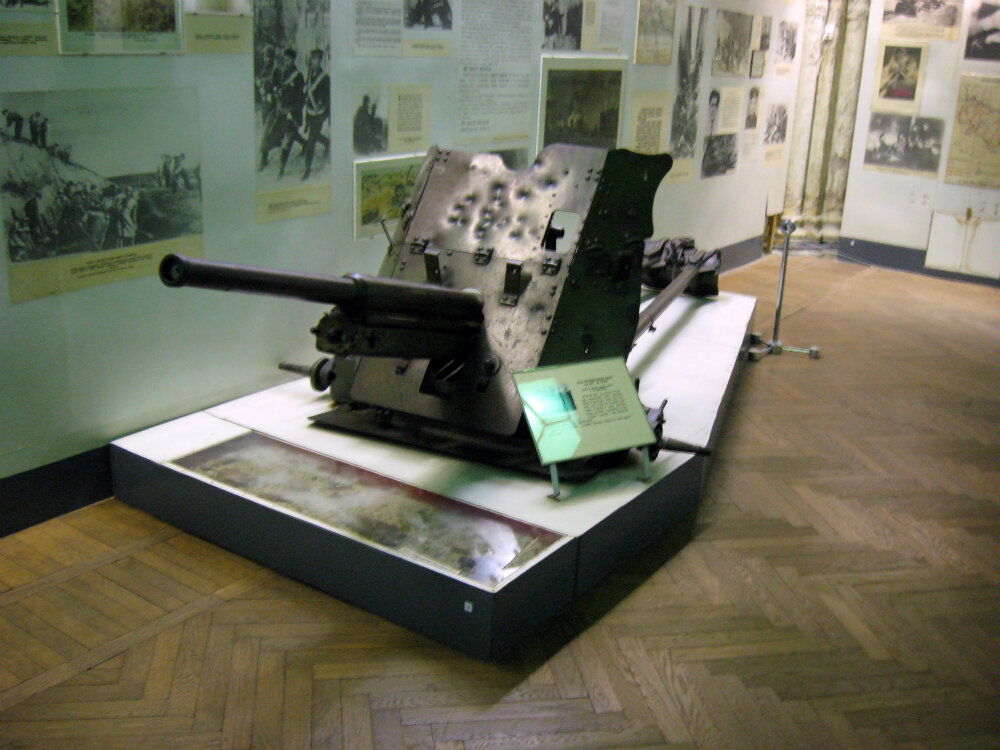 45-мм пушка сержанта Аликанцева в экспозиции Военно-исторического музея артиллерии, инженерных войск и войск связи. Санкт-Петербург. Под стеклом постамента — земля с осколками с Мамаева кургана. Таких осколков там было от 500 до 1250 на каждом квадратном метре.