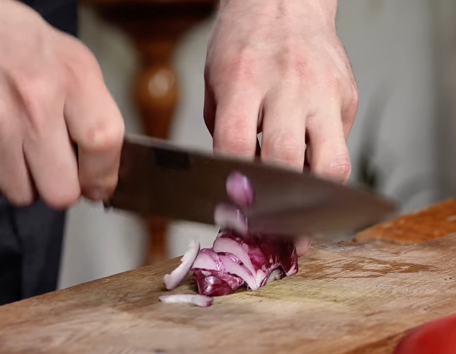 Лук нарезаем пером, кладем в миску. Добавляем кинзу (петрушку), но не нарезаем ее а отрываем листочки.