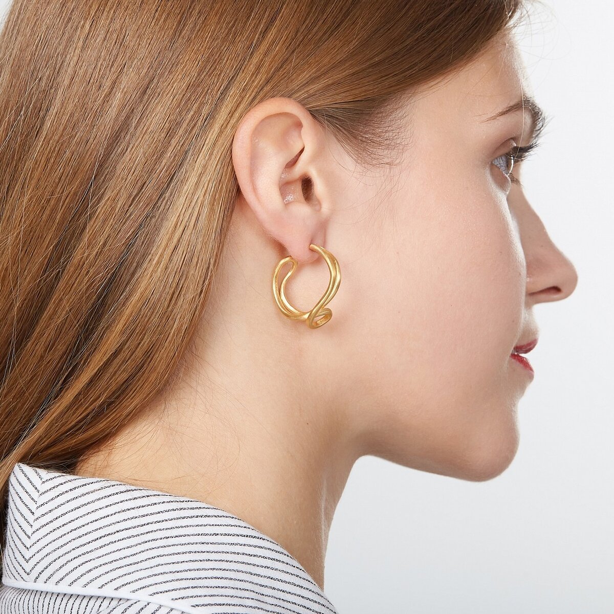 Золотые серьги на ушах у женщин
