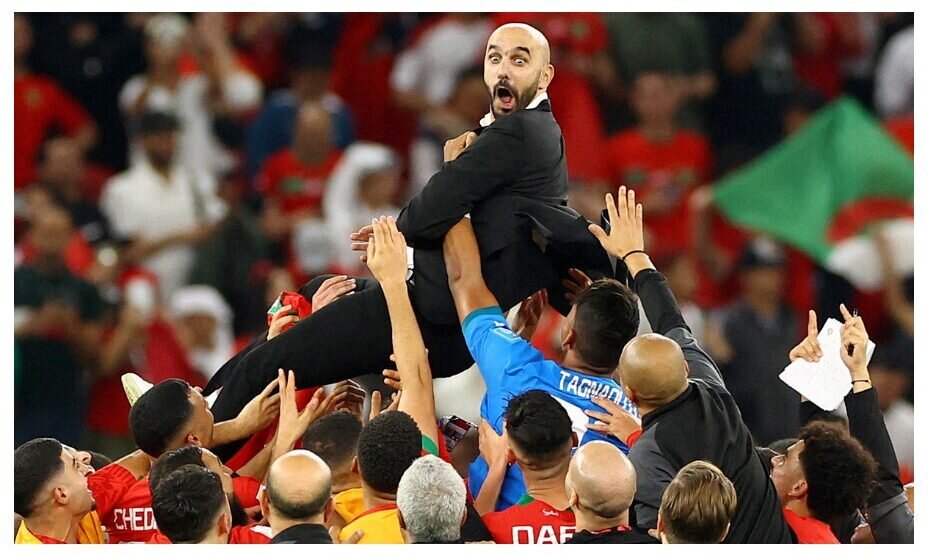    Футболисты сборной Марокко качают своего тренера Валида Реграги, празднуя выход в полуфинал ЧМ. Фото: Reuters