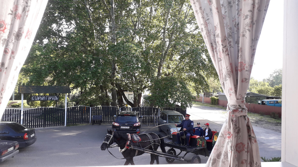 Рядом проезжают повозки с туристами