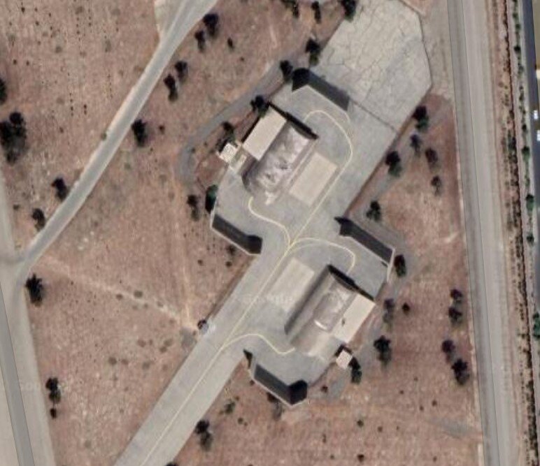 Фото из яндекс-карт. Иранская эскадрильская зона с укрытиями. Две арки со стенками перед входом-выходом. Видна линия руления и чёрные стенки. Простенько, истребитель сам заруливает.