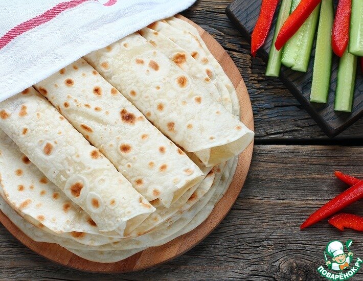 Лаваш – это пресный белый хлеб из пшеничной муки, который популярен у многих народов. Этот рецепт непременно стоит попробовать, он должен быть в арсенале любой хозяйки. Он поможет вам в любое время приготовить домашние тонкие лепешки и подать их на стол, завернув внутрь любую начинку.