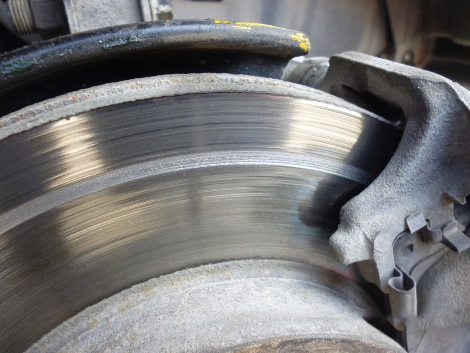 На фото отчетливо видно борозду от попавшего предмета между диском и колодкой