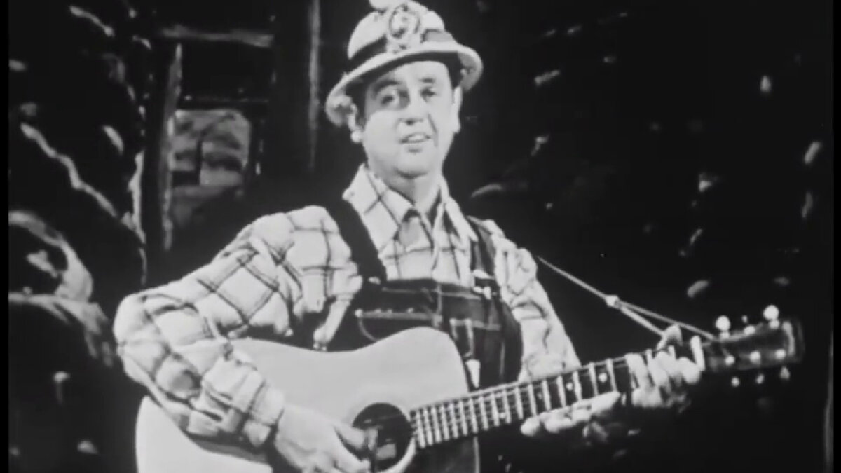 Merle Travis, автор и исполнитель кантри & вестерн, поёт «16 тонн» в шахтёрском шлеме той эпохи.