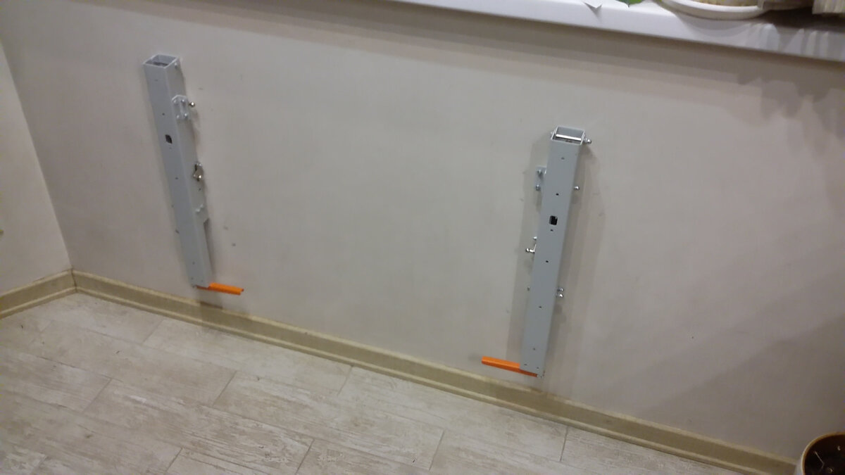 На стену крепим два складных кронштейна. Продаются комплектом, бывают разных цветов и размеров — для столешниц шириной от 40 до 70 см.