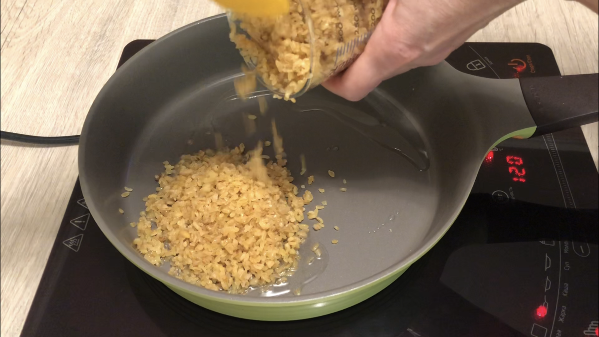 В сковороду влить растительное масло, добавить промытый булгур и обжаривать  на среднем огне, помешивая, пока не подрумянится