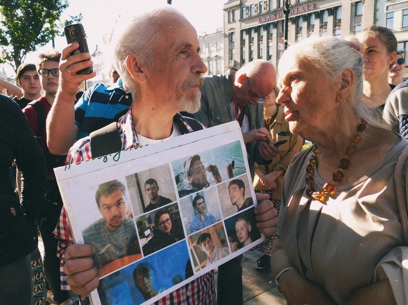 Один из активистов с фотографиями, по его мнению, несправедливо осужденных / Фото — Максим Мальцев «MeatingTime»