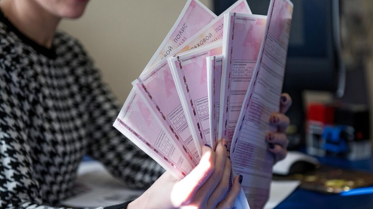    Сотрудник страховой компании демонстрирует страховой полис ОСАГО© РИА Новости / Алексей Мальгавко