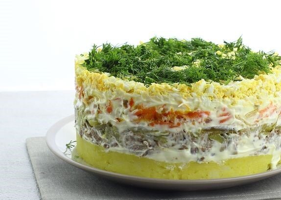 Вкусный, яркий и довольно сытный! Слоёный салат со шпротами, картофелем, морковью и маринованными огурцами непременно порадует всех за праздничным столом. Все ингредиенты в составе салата отлично гармонируют и дополняют друг друга. Салат настолько сытный, что его можно приготовить и подать как полноценное блюдо.