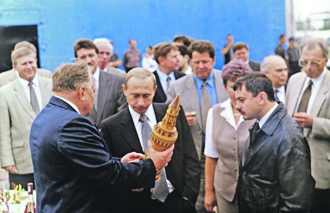 На снимке:  во время визита новоиспечённого  премьер-министра Путина новгородцы вручают ему пророческий подарок:  бутылку алкоголя в футляре в форме башни московского Кремля. 
