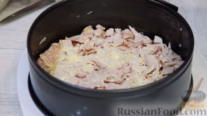 Собираем салат. Для его подачи я использовала форму для выпечки, так как специального кольца такого большого диаметра у меня нет.
Первый слой – это копчёное куриное филе. Этот слой немного скрепляем майонезом.