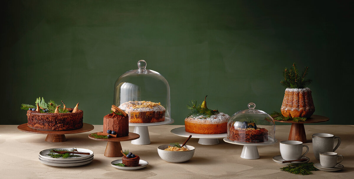 Сервировка праздничного стола: блюда на ножках из дерева и фарфора со стеклянными колпаками бренда Asa Selection