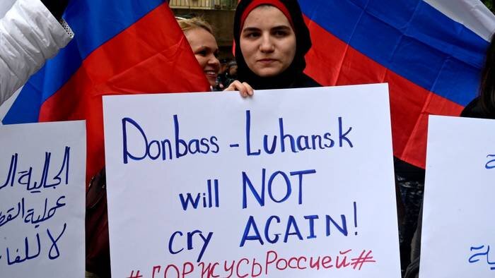 Ливан, Бейрут, улица возле посольства России. Протестующий несет плакат во время собрания в поддержку российской армии и ее военной операции на Украине / Фото: WAEL HAMZEH / EPA / ТАСС