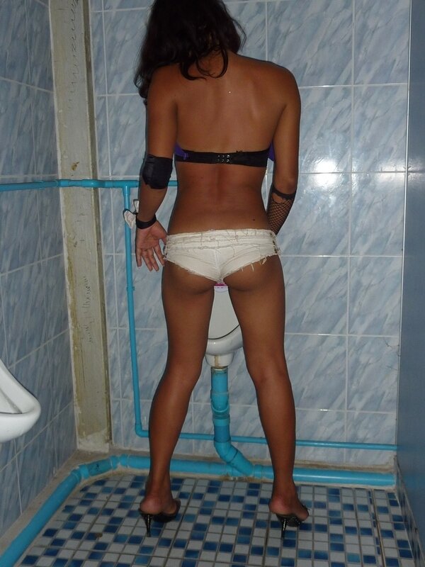 Женщина с прокладкой в трусах писает в туалете