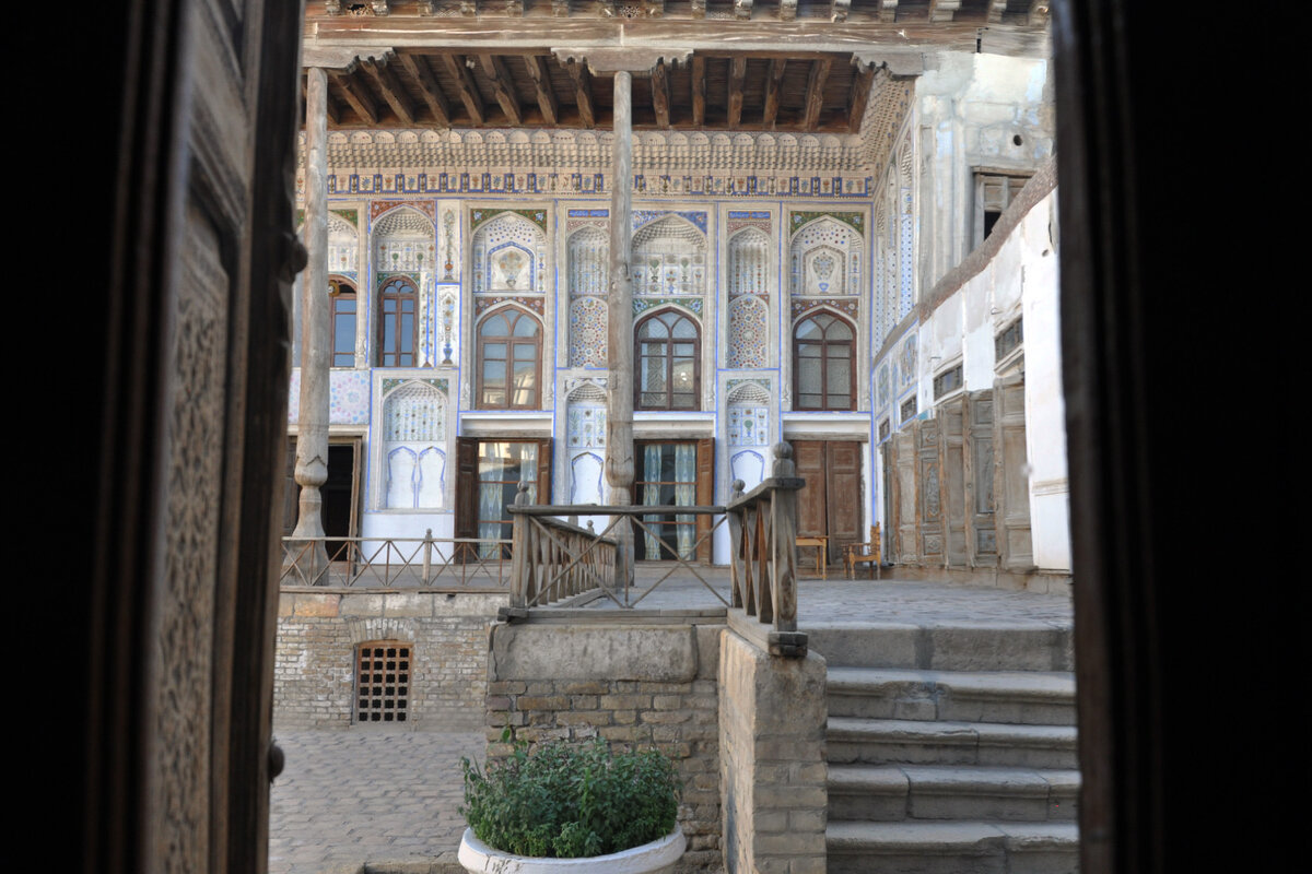 Вид из зала музея на айван главного дома. Справа от лестницы в правом крыле касса дома-музея.