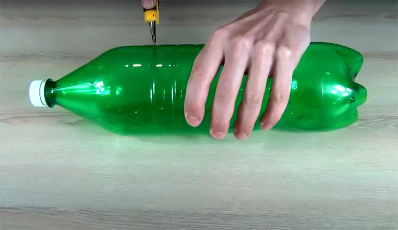 Её нужно разрезать пополам поперёк и вставить горлышко в низ бутылки‒ в часть с донышком. Вверху можно зафиксировать любым удобным для вас способом ‒ скотчем, обычным канцелярским степлером ‒ или просто спаять горячей спицей