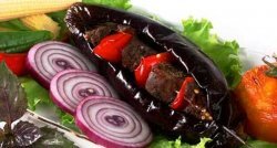 Зеленый лук очищают, промывают и нарезают на части длиной 6 - 10 см. репчатый лук шинкуют тонкими кольцами. Лимон нарезают дольками. У баклажан обрезают плодоножки, промывают, делают разрез вдоль и удаляют семена, в разрез укладывают тонко нарезанное сало, заправленное зеленью, стручковым перцем, солью; подготовленные баклажаны нанизывают поперек на шампур и жарят над раскаленными углями.