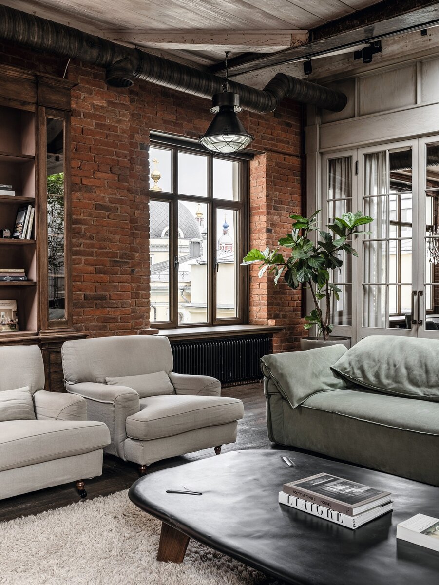 Фрагмент гостиной. Библиотека из антикварных материалов сделана на заказ, Joris Van Apers; кресла, De Padova. Реставрацией кирпичной кладки занимался Косс Мишин. Из окна открывается вид на церковь иконы Божией Матери “Всех Скорбящих Радость”. Фото: Михаил Лоскутов