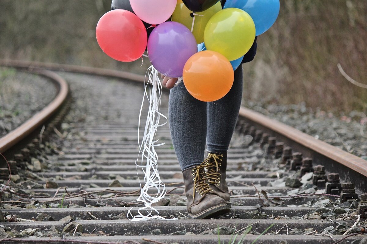Рельсы а воздушными шарами. Шарики на железной дороге. Девушка с воздушными шарами. Стеклянные шарики на железной дороге.