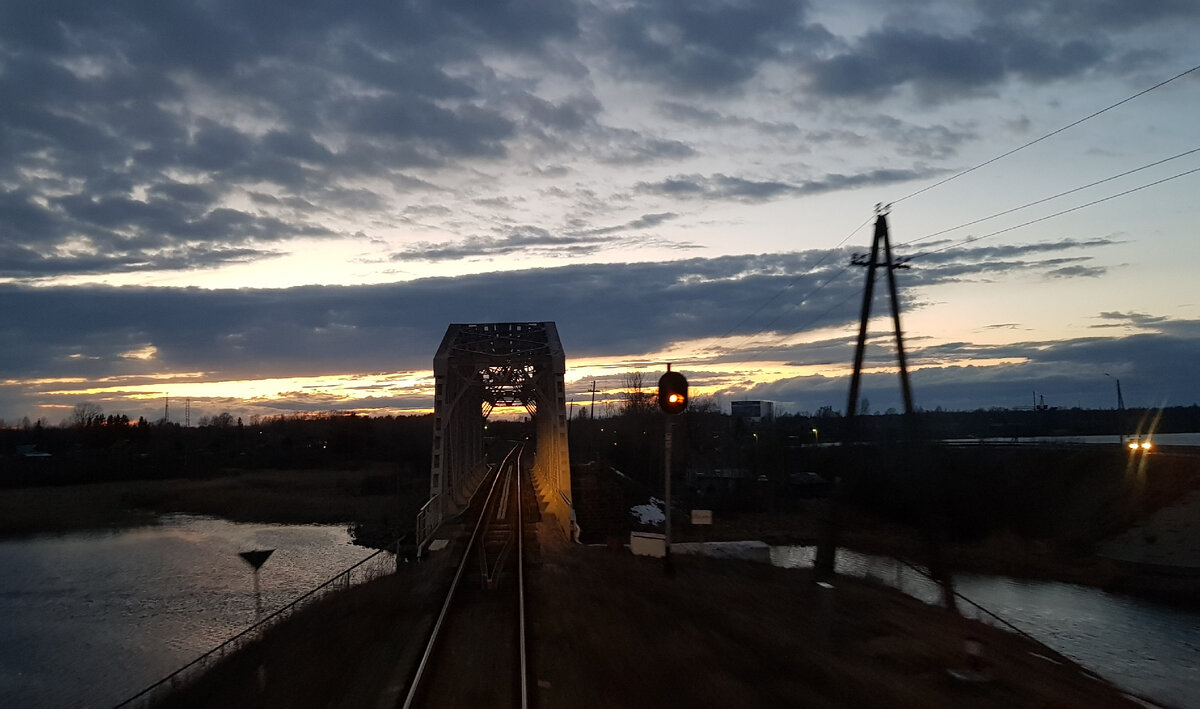 Железнодорожный мост через протоку селижаровского плёса озера Селигер и огни засыпающего Осташкова. Фото: Алексей Алексеев