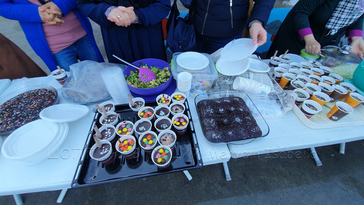 В стаканчиках пудинг, за ним картофельный салат, справа мокрый кекс, может брауни, и потом опять стаканчики с пудингом