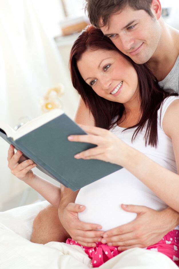 Книга беременна от мужа. Будущие родители. Чтение беременной. Муж и жена читают книгу.