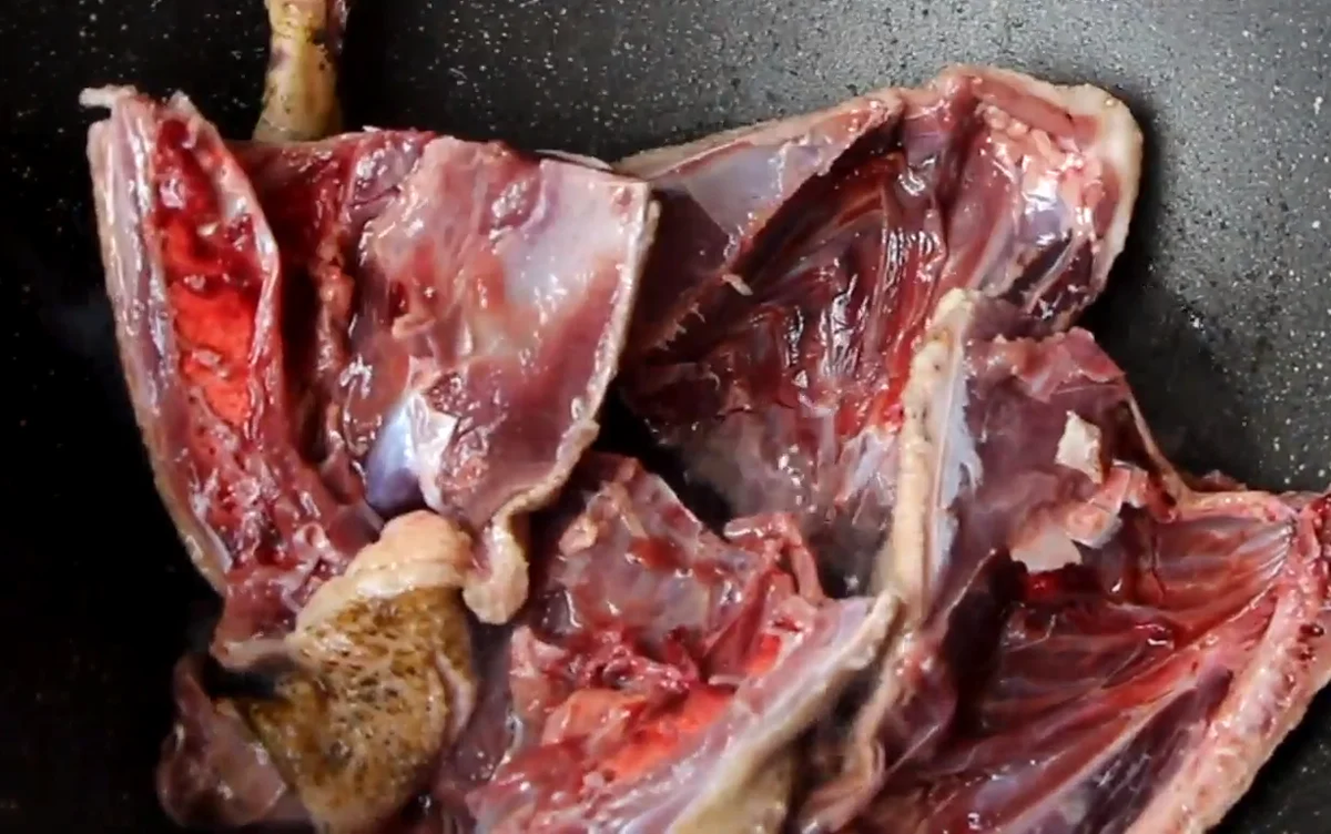 В разогретый на сильном огне казан добротно влить растительного масла и отправить в него порционные куски утки.