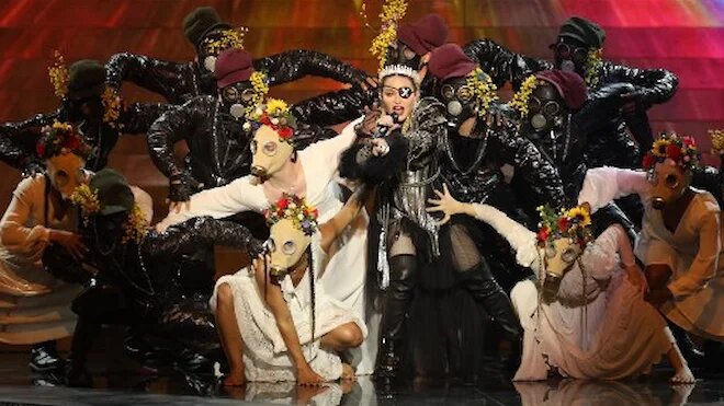 Жертвой коронавирусного безумия стала Мадонна. А все потому, что, эпатируя публику, она выступила в костюме смерти с короной на голове, а на подтанцовке у нее была группа в противогазах 

Фото: KAN / AFP