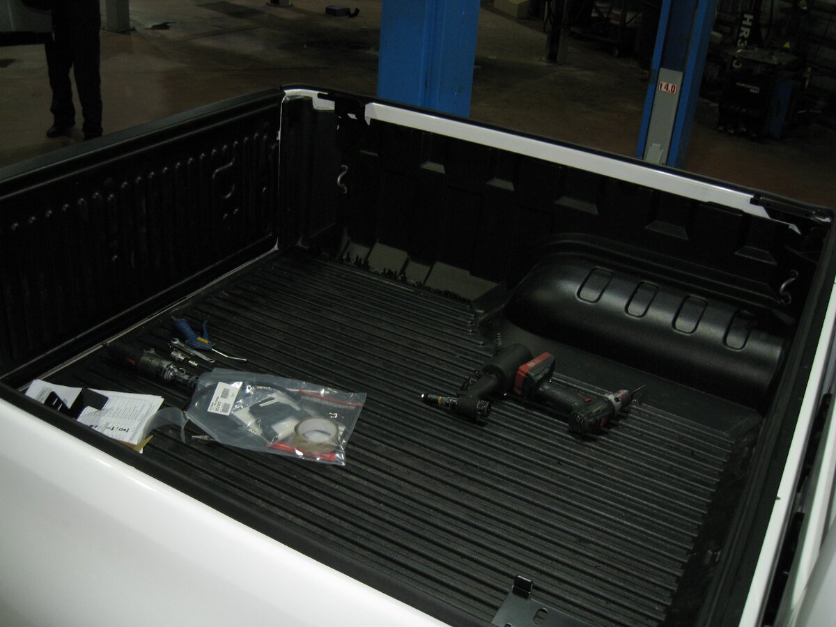 Установка вкладыша из пластика в грузовой отсек автомобиля. Штатные петли для фиксации груза крепятся к металлу кузова