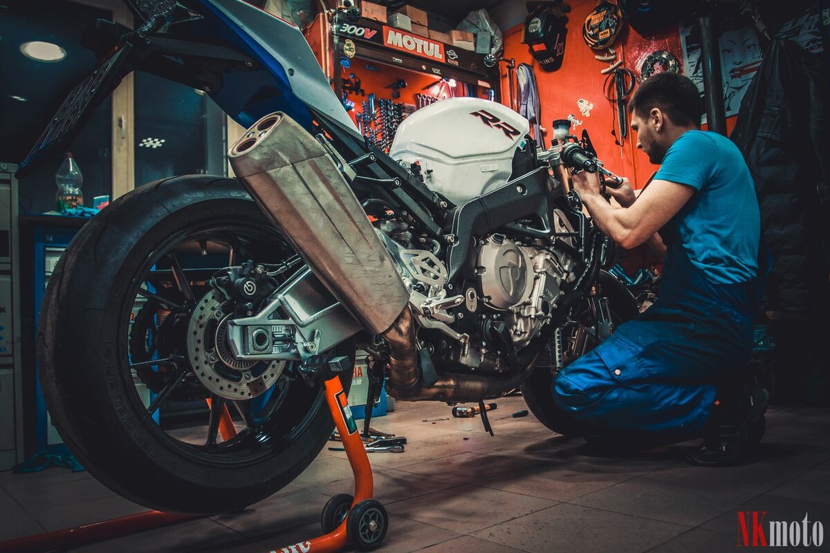 Сервис мотоциклов. Авто мото механика. Механик чинит мотоцикл. Авто мото механика. Кастом мастерская мотоциклов.
