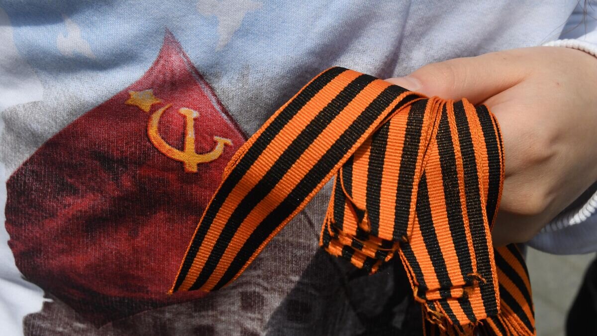    Волонтер Победы раздает прохожим георгиевские ленточки в центре Владивостока© РИА Новости / Виталий Аньков